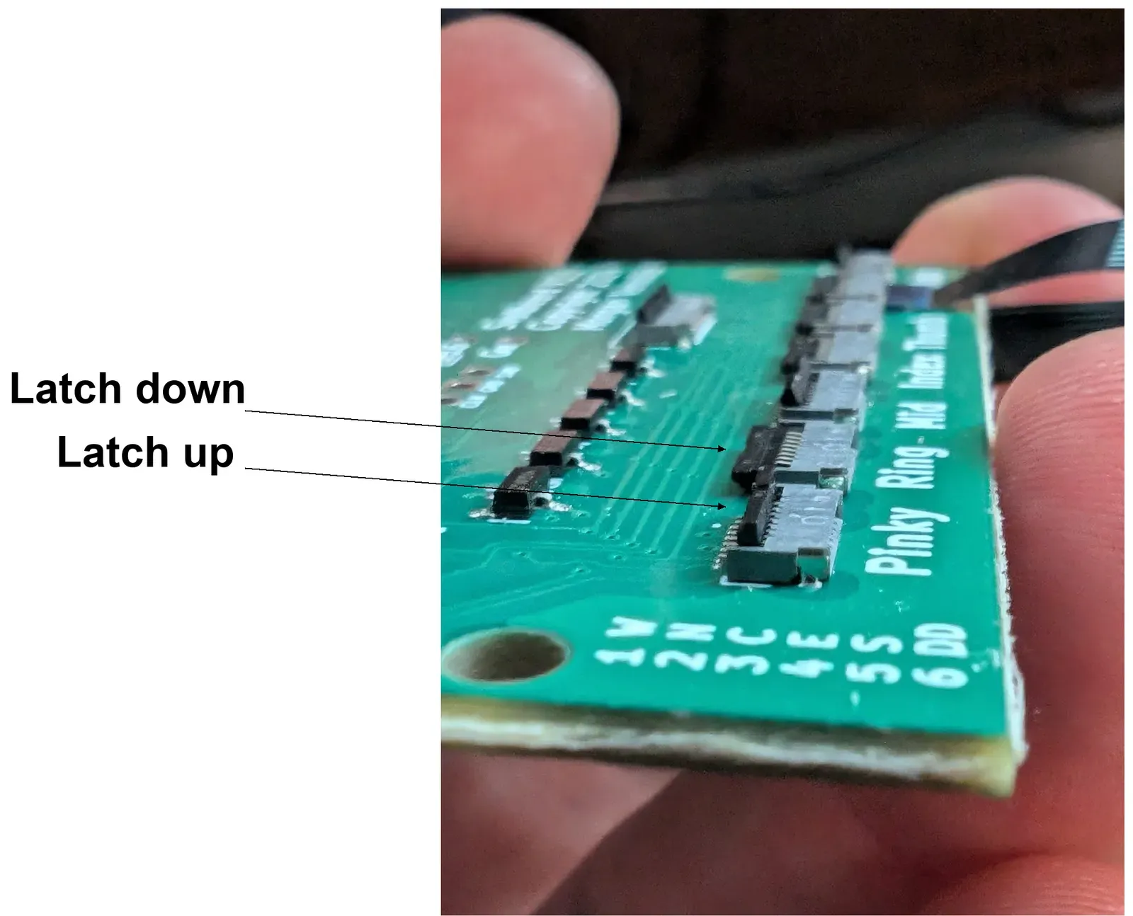 An MCU’s FFC connectors up close. One latch is down (closed) and one is up (open).