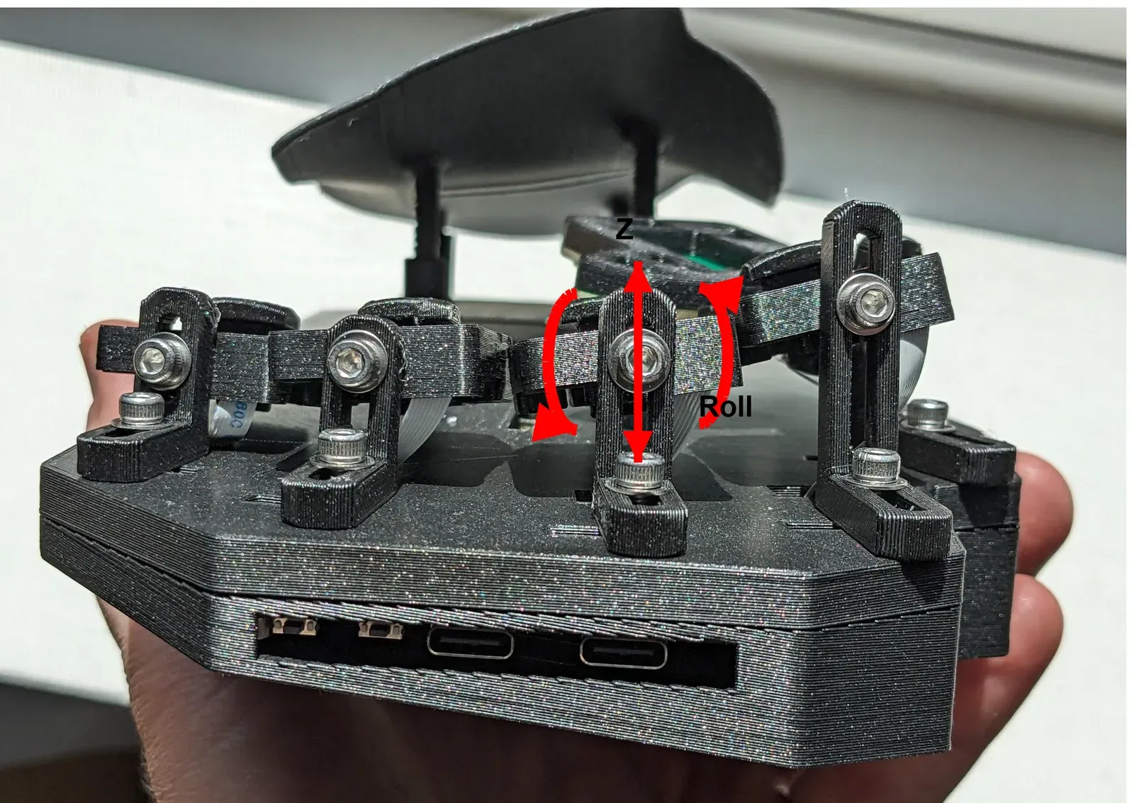 A Svalboard half from the side. Red arrows show the Z (height) and roll movement of a cluster on its tower.